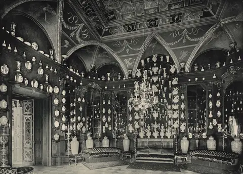 Historische Schwarz-Weiß-Fotografie des Turmzimmers voller Porzellan
