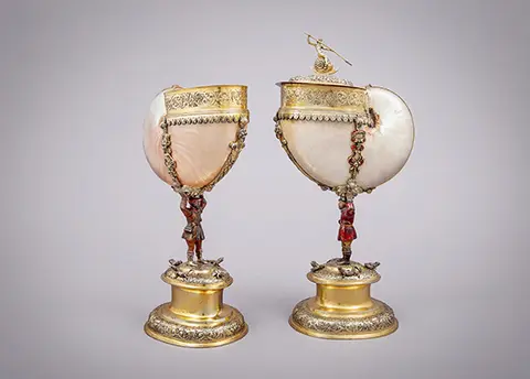 zwei große Muschelgefäße auf einem Sockel mit goldenen Verzierungen