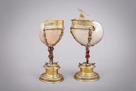 zwei große Muschelgefäße auf einem Sockel mit goldenen Verzierungen